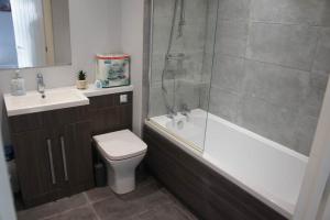 une salle de bains avec douche, toilettes et lavabo dans l'établissement Melbourne House Gem Stylish 2-bed In City Centre, à Accrington