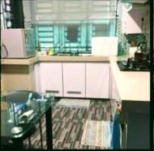 a kitchen with white cabinets and a counter top at SK Homestay Bukit Rangin Kuantan in Kuantan