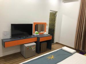 a room with a tv and a desk with a mirror at Holiday Hotel 2 in An Khê +16 photos
