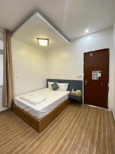 a bedroom with a bed and a wooden floor at Holiday Hotel 2 in An Khê