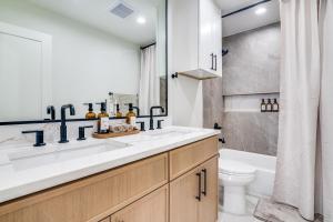 a bathroom with a sink and a toilet and a tub at The Goph Getaway 4B 2B Duplex KING Pet Friendly in Richardson