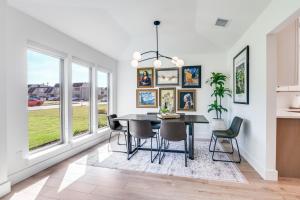 a dining room with a table and chairs and windows at The Goph Getaway 4B 2B Duplex KING Pet Friendly in Richardson