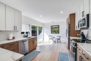 a kitchen with wooden floors and white cabinets at The Goph Getaway 4B 2B Duplex KING Pet Friendly in Richardson +4 photos