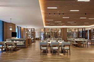 a restaurant with tables and chairs in a room at Delta Hotels by Marriott Jiuzhaigou in Jiuzhaigou