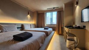 a hotel room with two beds and a television at 艾睏設計行旅 Sleepie Design Hotel in T'ien-liao