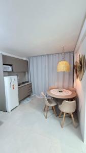 una cucina con tavolo, sedie e frigorifero di Mila rooftop apto 308 a Tamandaré