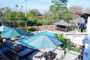 an overhead view of a swimming pool with umbrellas at Matappa Guest House in Pulau Sarang
