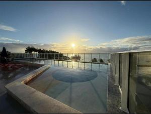 a view of a sunset from a building with a pool at Mila rooftop apto 308 in Tamandaré