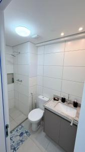 a white bathroom with a toilet and a sink at Mila rooftop apto 308 in Tamandaré +17 photos