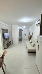 un soggiorno bianco con un divano e una TV di Mila rooftop apto 308 a Tamandaré Altre 17 foto
