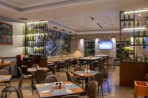 a restaurant with tables and chairs and a tv at Casa Andina Select Tacna in Tacna