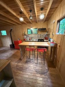 a kitchen with a counter and four chairs in a room at Cabaña Oma Iguazú in Puerto Iguazú