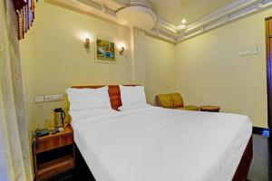 蒂鲁奇奇拉帕利Hotel O Royal的卧室里有一张白色的大床和一张书桌