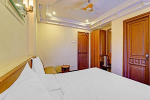 蒂鲁奇奇拉帕利Hotel O Royal的卧室里有一张白色的床和一扇木门