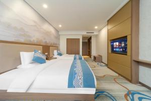 a hotel room with a large bed and a flat screen tv at Days Inn Xi'an City Center in Xi'an