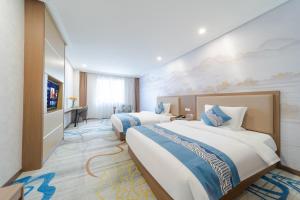a hotel room with two beds and a tv at Days Inn Xi'an City Center in Xi'an +36 photos