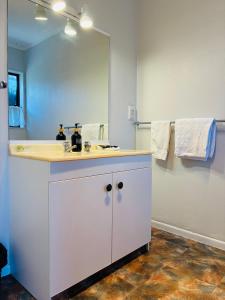 Un baño con lavabo y un espejo grande. en Awatea Park Motel, en Palmerston North