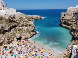 eine Gruppe von Menschen an einem Strand in der Nähe des Ozeans in der Unterkunft B&B Prestige in Polignano a Mare