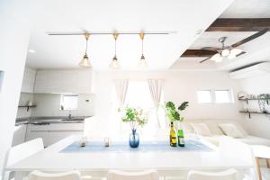eine weiße Küche mit einem weißen Tisch und Stühlen in der Unterkunft Shizuki no Sato Tsuki Terrace 531 - Vacation STAY 98450v in Awaji + 69 Fotos