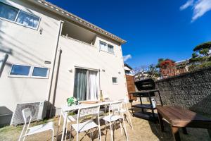 eine Terrasse mit einem Tisch, Stühlen und einem Grill in der Unterkunft Shizuki no Sato Tsuki Terrace 531 - Vacation STAY 98450v in Awaji