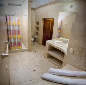 y baño con lavabo y ducha. en Hostal Bubamara, en Arequipa
