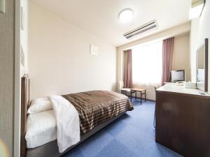 a hotel room with a bed and a sink at 佐久一萬里温泉ホテル in Saku +10 photos