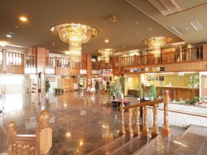 a large lobby with chandeliers in a building at 佐久一萬里温泉ホテル in Saku