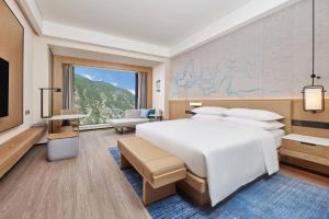 a bedroom with a large bed and a large window at Delta Hotels by Marriott Jiuzhaigou in Jiuzhaigou +50 photos