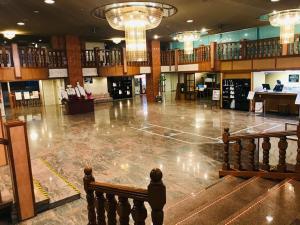 a large lobby with a large empty floor with lights at 佐久一萬里温泉ホテル in Saku