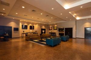 a large living room with couches and blue chairs at Casa Andina Select Tacna in Tacna