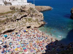 uma multidão de pessoas numa praia perto do oceano em B&B Prestige em Polignano a Mare