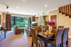 een eetkamer en woonkamer met een tafel en stoelen bij Platinum Queenstown in Queenstown