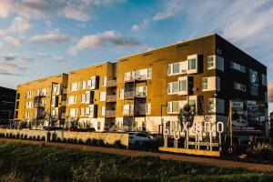 ein großes gelbes Gebäude mit einem Auto davor in der Unterkunft The Spot Pet Friendly Furnished 3 Bedrooms Rental in Winnipeg 116 in Tuxedo