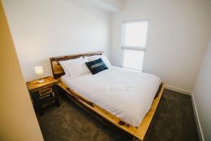 Bett in einem kleinen Zimmer mit Fenster in der Unterkunft The Spot Pet Friendly Furnished 3 Bedrooms Rental in Winnipeg 116 in Tuxedo
