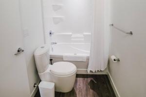 ein weißes Badezimmer mit Toilette und Badewanne in der Unterkunft The Spot Pet Friendly Furnished 3 Bedrooms Rental in Winnipeg 116 in Tuxedo + 1 Foto