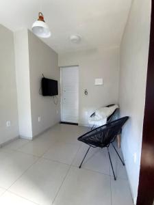 ein Wohnzimmer mit Sessel und Fernseher in der Unterkunft Natal em Garanhuns, PE - Apartamento minimalista próximo ao Centro in Garanhuns