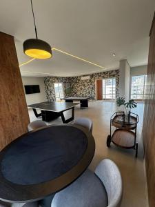 Praia Grande Boqueirão في برايا جراندي: غرفة معيشة بها طاولة وكراسي