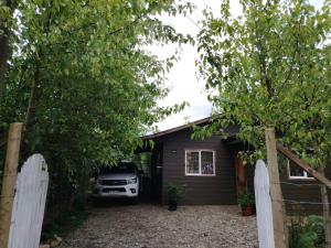 a car parked in front of a small house at Kabañas Bosque De Alamos in Puerto Aisén