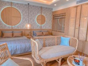 a bedroom with a bed and a wicker chair at FLC Sea Tower QUY NHƠN-Căn Hộ Du Lịch 5 Sao-Cách Biển 40m-Hồ Bơi-View Biển in Quy Nhon