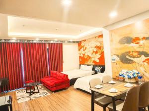a hotel room with a bed and a red chair and a table at FLC Sea Tower QUY NHƠN-Căn Hộ Du Lịch 5 Sao-Cách Biển 40m-Hồ Bơi-View Biển in Quy Nhon +21 photos