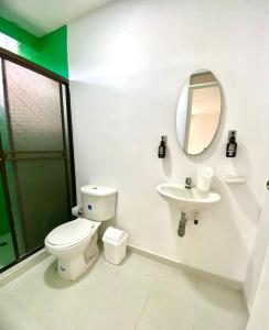 a bathroom with a toilet and a sink and a mirror at Apartamento Boutique Cartagena Plaza de Toros in Cartagena de Indias