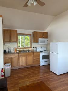 a kitchen with a white refrigerator and wooden cabinets at Cliffside Hideaway-Renovations & upgrades coming! in Hammond