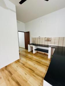 - un salon avec une table et du parquet dans l'établissement Manikya Homestay, à Malpe