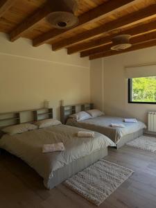 two beds in a room with wooden ceilings at Exclusive luxury house in a great location - 12 guest in Lago Puelo