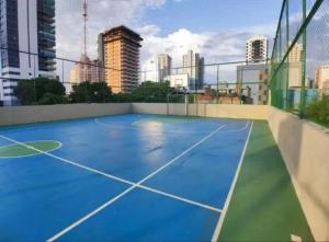 a tennis court with a city skyline in the background at Apt 3 quartos com área de lazer in Belém