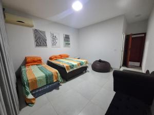 a bedroom with two beds and a couch at Chácara Lótus in Trindade +19 photos