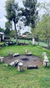 a park with benches and logs in the grass at Lijo Ruban Home Stay in Kodaikānāl +3 photos