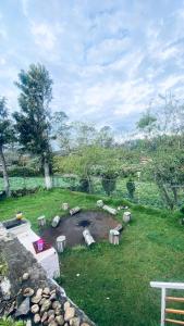 a yard with a pond with benches in the grass at Lijo Ruban Home Stay in Kodaikānāl