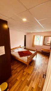 a bedroom with a bed in a room with wooden floors at Lijo Ruban Home Stay in Kodaikānāl