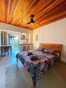 ein Schlafzimmer mit einem Bett und einer Holzdecke in der Unterkunft Hakuna Studios Barra do Sahy in Barra do Sahy